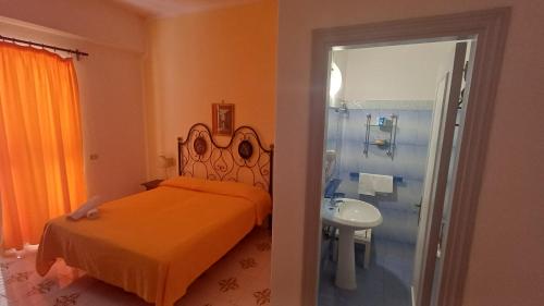 a bedroom with a bed and a bathroom with a shower at Hotel Belsole in Forio d'Ischia