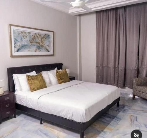a bedroom with a large bed and a window at Adonai Hotel & Apartment in Spintex