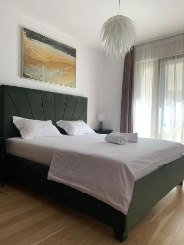 a bedroom with a large bed with a green headboard at Luxury Central Monarch Residence Apartment Sleeps 5 in Timişoara