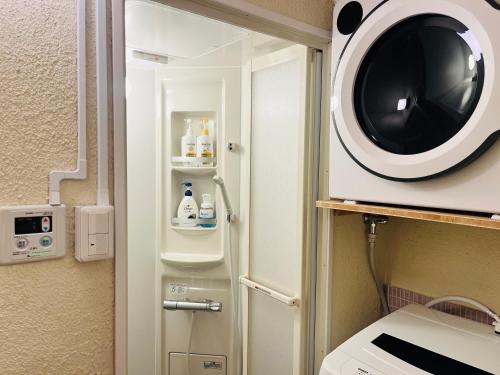 a bathroom with a washing machine in a room at Odawara Nautical Nook in Odawara