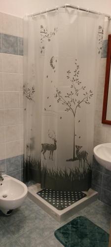 a bathroom with a shower curtain with a tree and animals at Oasi della Divina Volontà in San Giovanni Rotondo