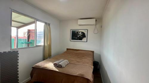 a small bed in a small room with a window at Aurora in Carmelo