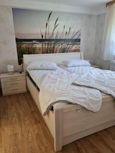 a bedroom with a large white bed with a window at Seestern in Rerik