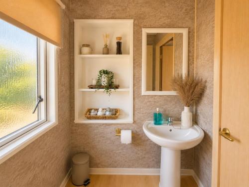 a bathroom with a sink and a mirror at Seaside Escape at St Osyth in Clacton-on-Sea