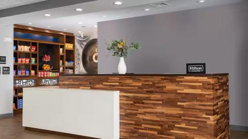 a store with a counter with a vase of flowers at Hampton Inn Chelsea, Mi in Chelsea