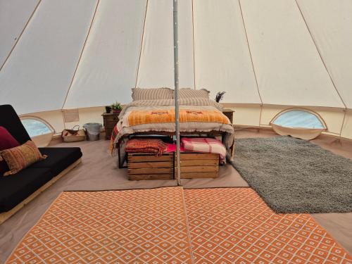 a bedroom with a bed in a tent at Lyng Farm Campsite in Brisley