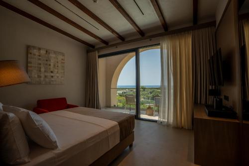 a bedroom with a bed and a large window at Carpe Diem Hotel in Borsh