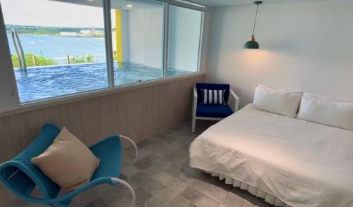 a bedroom with a bed and a chair and a window at 南灣飯店 Kenting Nanwan Hotel in Nanwan