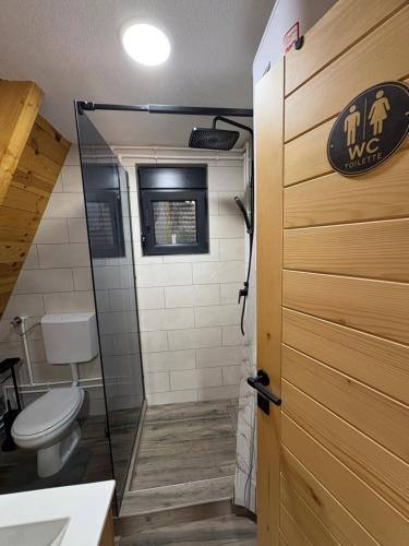 a bathroom with a toilet and a glass shower door at Cottage Magdalena in Žabljak