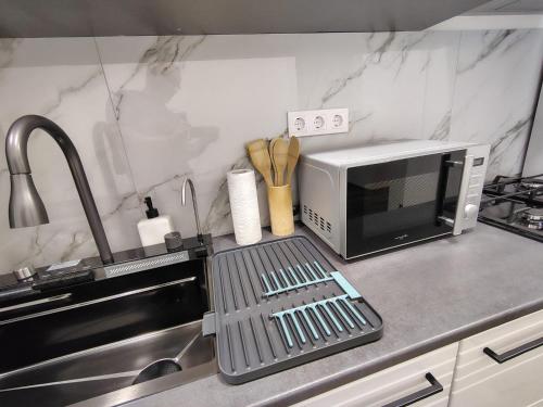 a kitchen counter with a microwave and a sink at David Apartament in Hunedoara