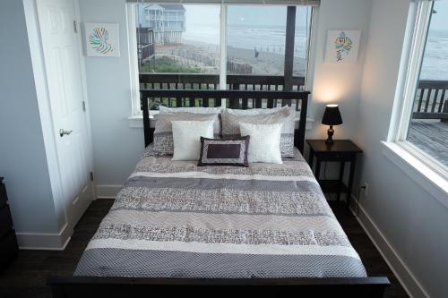 a bedroom with a bed with a view of the ocean at Beach Front on West Beach in Galveston