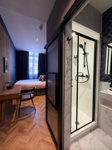 a bathroom with a shower and a bedroom at Hütel in Liverpool
