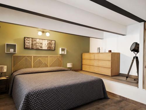 a bedroom with a bed and a dresser at Retro Chic in Saumur