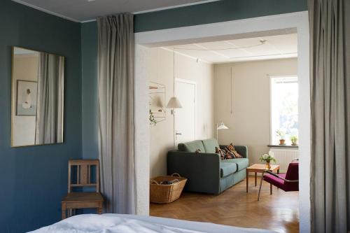a bedroom with a couch and a living room at Spjutstorp's old school and rectory, 1 in Tomelilla