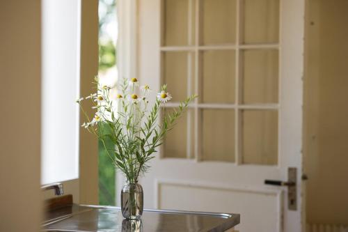 a vase filled with white flowers sitting on a table at Spjutstorp's old school and rectory, 1 in Tomelilla
