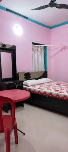 a bedroom with two beds and a red chair at Rose Villa Kovalam in Kovalam