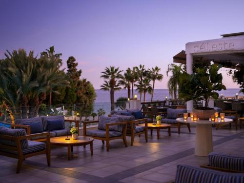 a hotel patio with tables and chairs and the ocean at Mediterranean Beach Hotel in Limassol