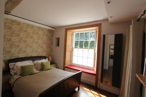 a bedroom with a bed and a window at The Lawns Spa Apartment in Holt