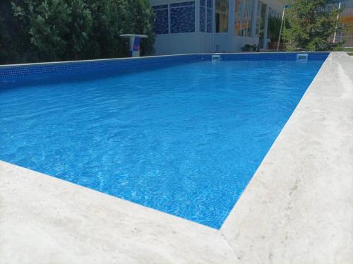 a large swimming pool with blue water at Sunny House in Kranevo