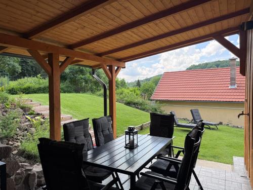 a wooden table and chairs under a wooden pergola at Altum Mátra Vendégház in Mátraszentimre