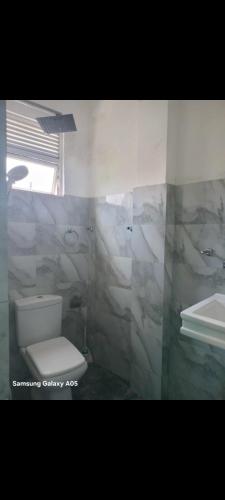 a bathroom with a white toilet and a sink at Jaans Inn in Ratmalana South