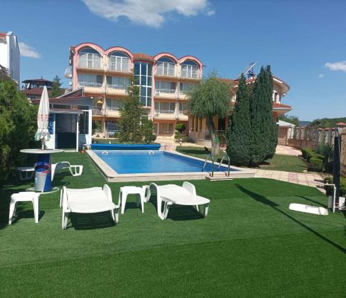 a yard with a pool and chairs and a building at Sunny House in Kranevo