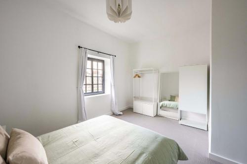a white bedroom with a bed and a window at Seven Space - The Old Post Office Court in Norwich