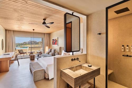 a bathroom with a bed and a sink in a room at Fouquet's Mykonos in Mikonos