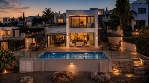 a house with a swimming pool in front of it at Blue Infinity Villa 33 in Neo Chorio