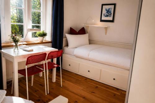 a small room with a bed and a desk and a mirror at Zugvogel EG in Wangerland