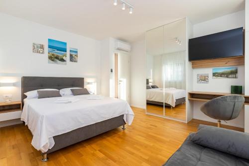 a bedroom with a large bed and a couch at Penthouse Petar in Kastel Stari