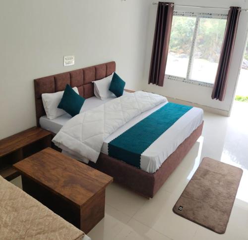 a bedroom with a large bed and a table at Uttarkashi Resort in Uttarkāshi