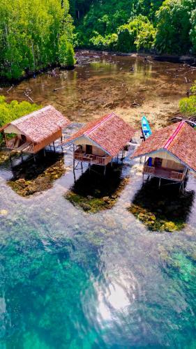 an aerial view of a group of huts in the water at Mangrove Reef Guest House in Airborei