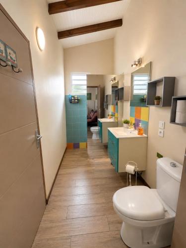 a bathroom with two toilets and a sink and a toilet istg at Gîte Avocatier - Villa Marina in Bouillante