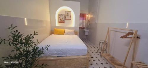 a small bedroom with a bed and a plant at Tran Phu Riverside House in Can Tho