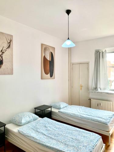 a bedroom with two beds and a pendant light at Belga Apartment 3 bedrooms. in Antwerp