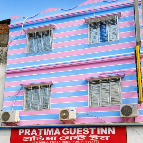 a pink and blue building with a sign on it at Hotel Protima guest inn in Digha