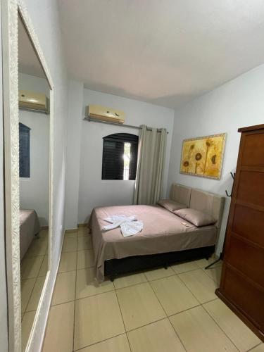 a small bedroom with a bed and a mirror at Residencial Mandi in Guaíra
