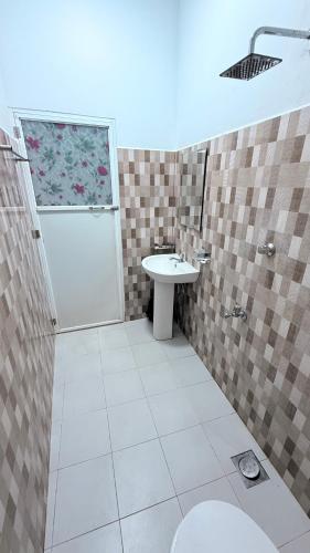 a bathroom with a shower and a toilet and a sink at Diving Nest in Trincomalee