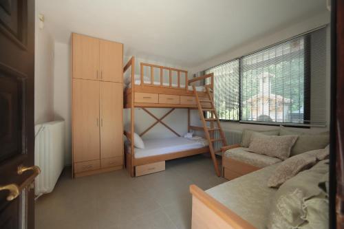 a small room with a bunk bed and a couch at River side house in Kastoria