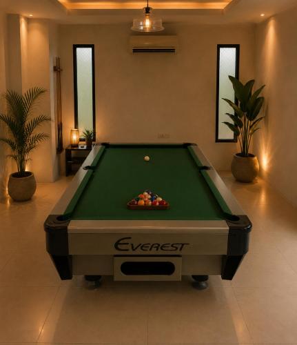 a pool table in a living room with a pool at Sunset Beach Inn in Hua Hin