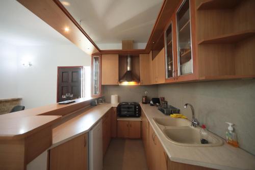 a kitchen with wooden cabinets and a sink at River side house in Kastoria
