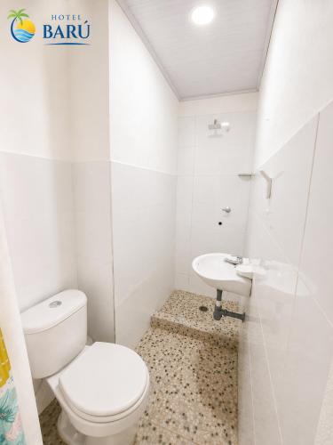 a white bathroom with a toilet and a sink at Hotel Barú Melgar in Melgar