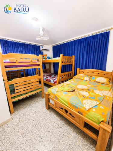 a bedroom with two bunk beds and blue curtains at Hotel Barú Melgar in Melgar