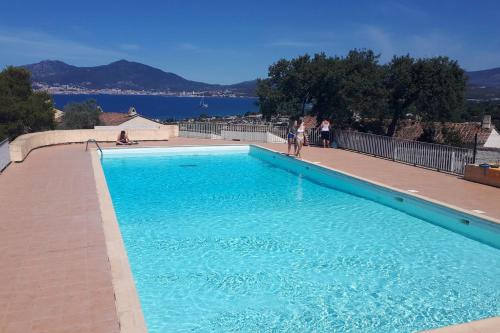 a large blue swimming pool with people standing around it at Beautiful 40 M2 With Pool Near The Beach! in Grosseto-Prugna