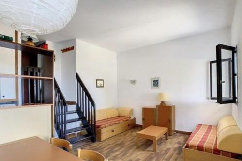a living room with a staircase and a couch at Beautiful 40 M2 With Pool Near The Beach! in Grosseto-Prugna