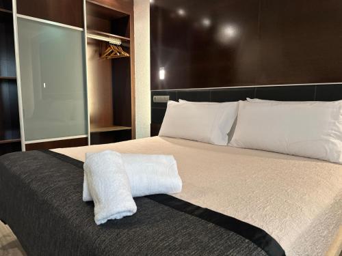 a bedroom with a large bed with white sheets and pillows at Puerta de Africa in Ceuta