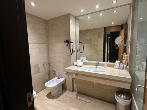 a bathroom with a sink and a toilet and a mirror at Puerta de Africa in Ceuta
