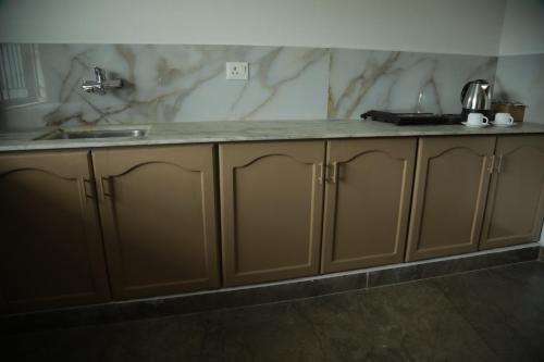 a kitchen with a sink and a counter top at Rivayn Suites in Thiruvalla