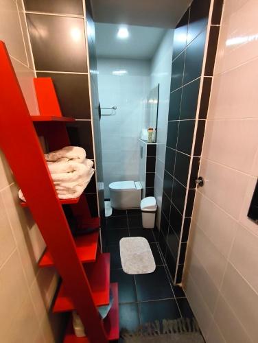 a small bathroom with a red ladder to a toilet at Топсоба12 in Niš